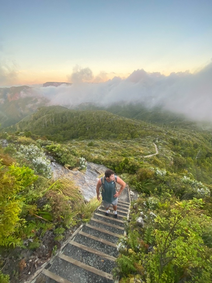 Tom hiking mountain stairs above the clouds